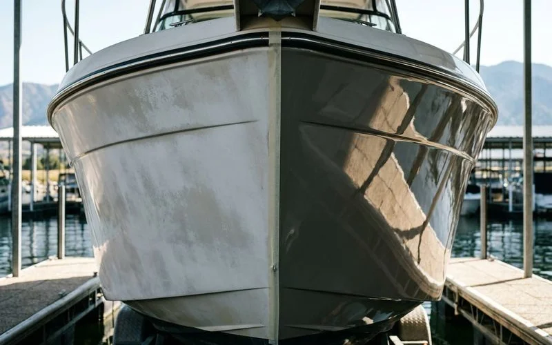 Close up comparison of oxidized versus restored gelcoat on boat hull showing dramatic difference in appearance